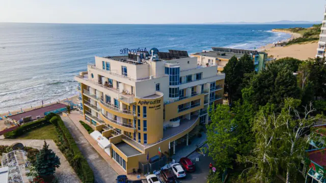 Будівля з написом Aphrodite Beach Hotel згори, а за нею — море й пляж