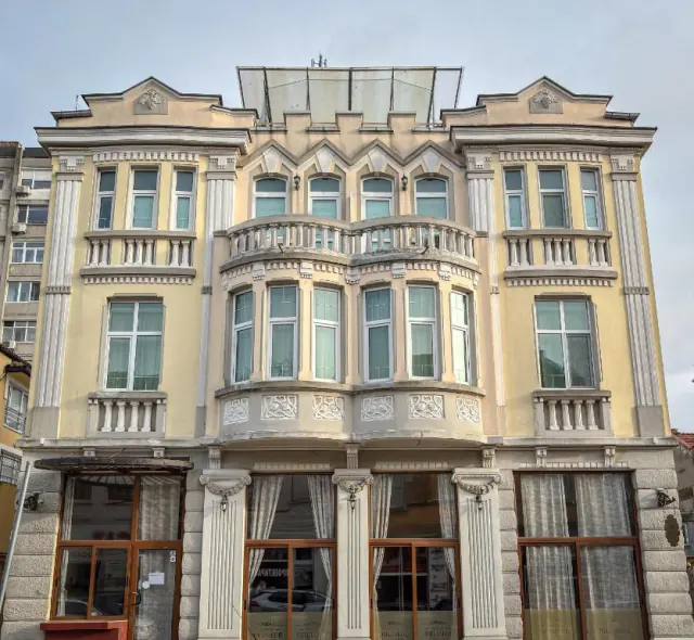 Žlutá secesní fasáda rodinného hotelu Chiplakoff s arkýři a balkony.