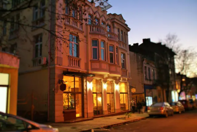 Budova hotelu za soumraku s osvětleným přízemím.