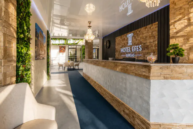 Recepce a lobby hotelu Efes s logem hotelu a křišťálovými lustry.