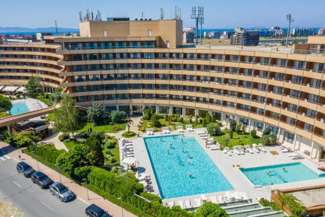Grand Hotel Pomorie z výšky – zakřivená budova, bazény a zahrada.