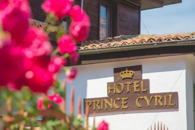 Вивіска Hotel Prince Cyril із короною, на передньому плані — рожеві троянди