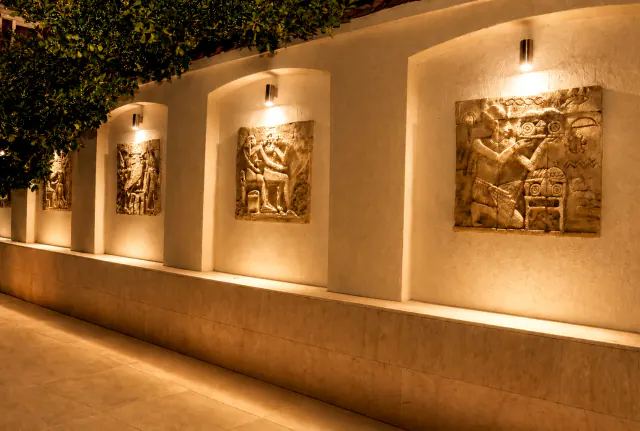 Basreliéfy v egyptském stylu v osvětlených výklencích na nádvoří hotelu Luxor.