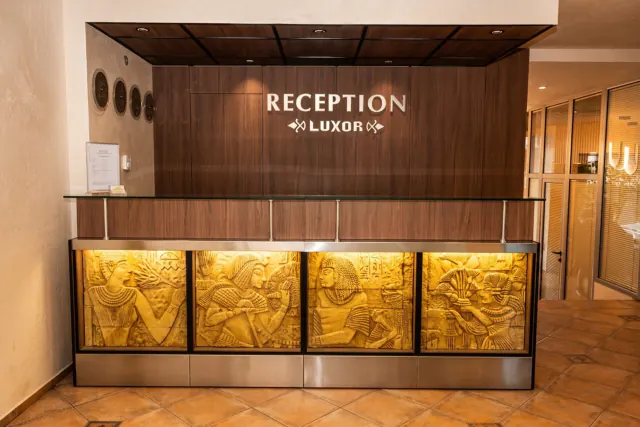 Recepce hotelu Luxor s egyptskými reliéfy na pultu.