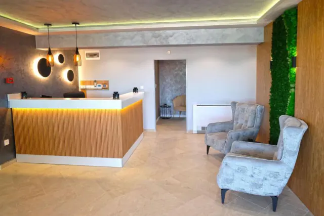 Recepce Hotelu Paradise s křesly a stěnou ze zeleného mechu.