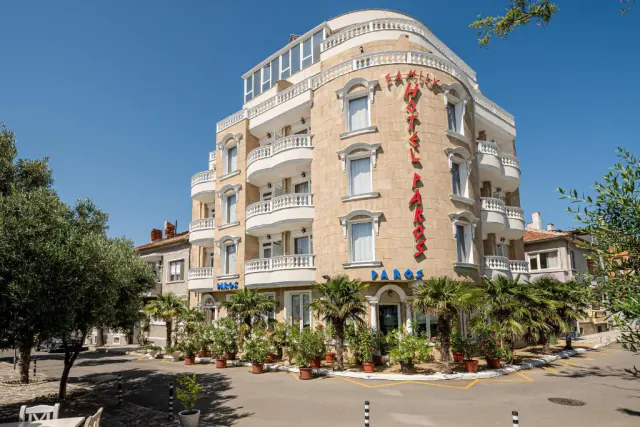 Hotel Paros ve Starém Městě v Pomorii – fasáda s červeným nápisem a palmami u vchodu.
