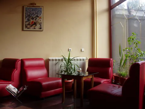 Lobby hotelu Prestige s červenými koženými pohovkami.