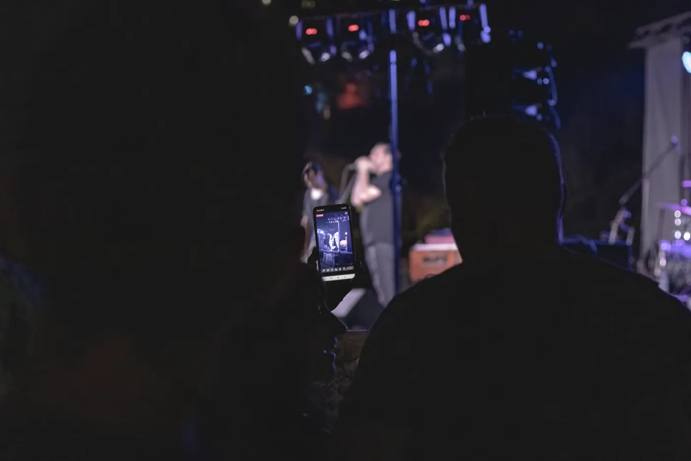 Publiczność filmuje telefonem wieczorny koncert na żywo podczas July Morning na plaży w Burgasie