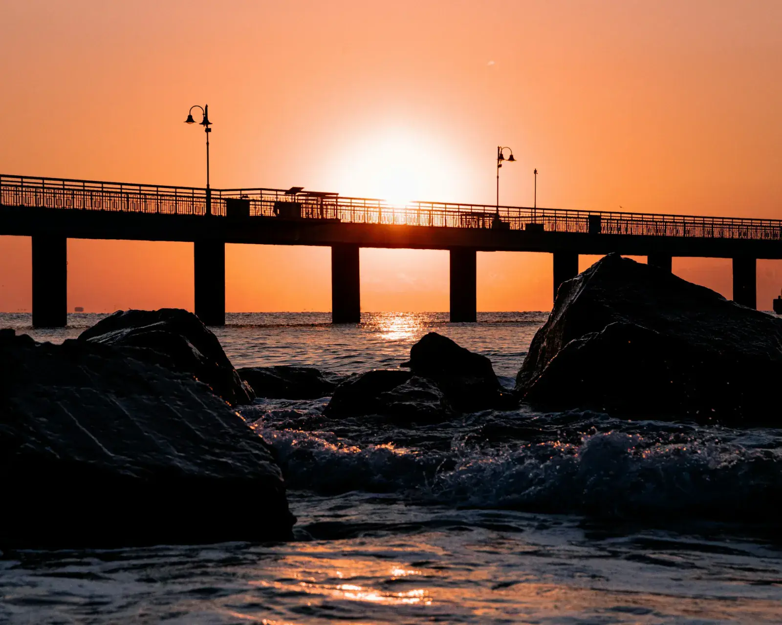 Eine Brücke über dem Wasser bei Sonnenuntergang